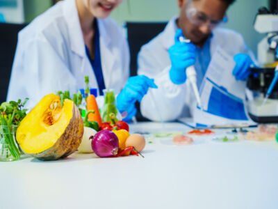 Reliable middle-aged Asian male researcher collaborates with experienced gray-haired elderly Asian female nutritionist in laboratory, focusing on food ingredients, extracts, nutrition and health.